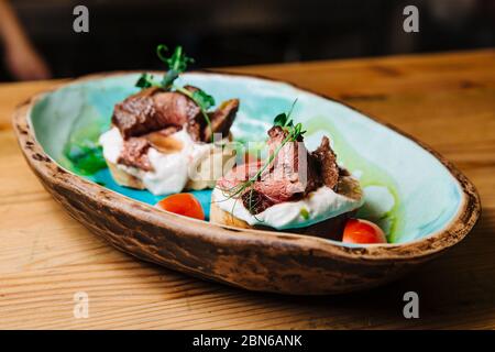 Bruschetta mit Roastbeef auf Zwiebel Brot medium gebratenes Roastbeef und saurer Sahne-Sauce. Leckere Snacks, Sandwiches. Stockfoto