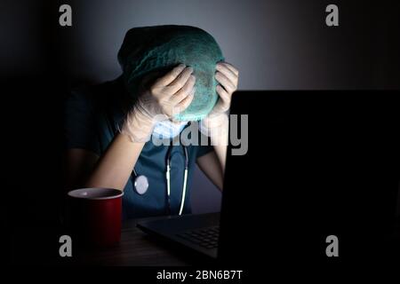 Kaukasische Frau Arzt Krankenschwester in chirurgischen Maske sieht müde, erschöpft in der Nacht wegen Covid Stockfoto