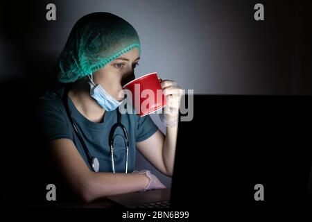 Kaukasische Frau Arzt Krankenschwester in chirurgischen Maske sieht müde, erschöpft in der Nacht wegen Covid Stockfoto