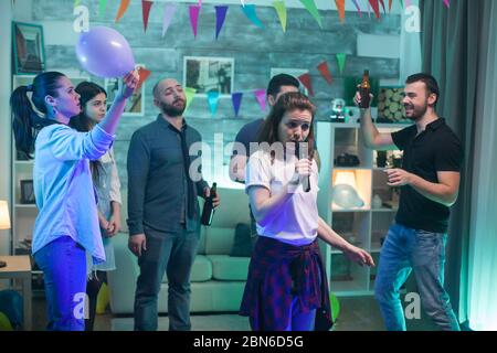 Gruppe von Freunden spielen Karaoke zu Hause Party. Unterhaltung für die Leute. Stockfoto