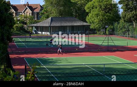 Brighton UK 13. Mai 2020 - Tennisspieler nehmen an den Plätzen im Queens Park Brighton früh am Morgen nach der Lockerung einiger Coronavirus Lockdown Maßnahmen in England. Einige Lockdown-Maßnahmen wurden in England von Boris Johnsons Regierung gelockert, einschließlich Tennis oder Golf während der Coronavirus COVID-19 Pandemie. : Credit Simon Dack / Alamy Live News Stockfoto