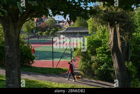 Brighton UK 13. Mai 2020 - Tennisspieler nehmen an den Plätzen im Queens Park Brighton früh am Morgen nach der Lockerung einiger Coronavirus Lockdown Maßnahmen in England. Einige Lockdown-Maßnahmen wurden in England von Boris Johnsons Regierung gelockert, einschließlich Tennis oder Golf während der Coronavirus COVID-19 Pandemie. : Credit Simon Dack / Alamy Live News Stockfoto