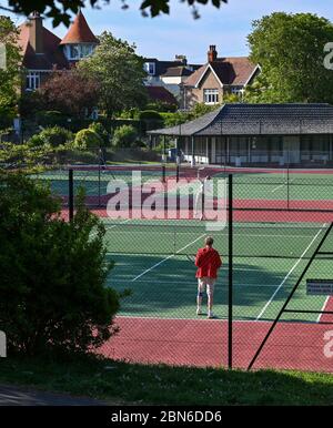 Brighton UK 13. Mai 2020 - Tennisspieler nehmen an den Plätzen im Queens Park Brighton früh am Morgen nach der Lockerung einiger Coronavirus Lockdown Maßnahmen in England. Einige Lockdown-Maßnahmen wurden in England von Boris Johnsons Regierung gelockert, einschließlich Tennis oder Golf während der Coronavirus COVID-19 Pandemie. : Credit Simon Dack / Alamy Live News Stockfoto