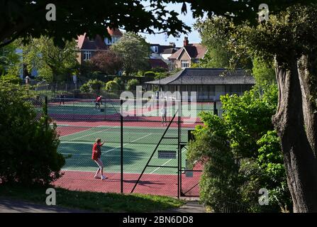 Brighton UK 13. Mai 2020 - Tennisspieler nehmen an den Plätzen im Queens Park Brighton früh am Morgen nach der Lockerung einiger Coronavirus Lockdown Maßnahmen in England. Einige Lockdown-Maßnahmen wurden in England von Boris Johnsons Regierung gelockert, einschließlich Tennis oder Golf während der Coronavirus COVID-19 Pandemie. : Credit Simon Dack / Alamy Live News Stockfoto