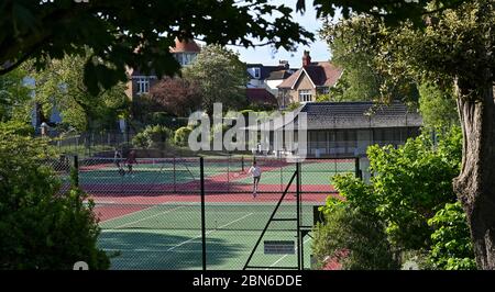 Brighton UK 13. Mai 2020 - Tennisspieler nehmen an den Plätzen im Queens Park Brighton früh am Morgen nach der Lockerung einiger Coronavirus Lockdown Maßnahmen in England. Einige Lockdown-Maßnahmen wurden in England von Boris Johnsons Regierung gelockert, einschließlich Tennis oder Golf während der Coronavirus COVID-19 Pandemie. : Credit Simon Dack / Alamy Live News Stockfoto