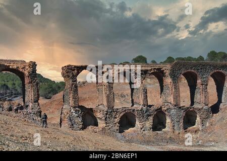 Sonnenuntergangslandschaft mit einem alten, ruinierten Aquädukt Stockfoto