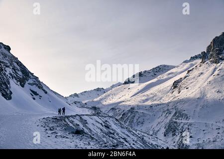 Zwei Wanderer sind Klettern auf der Strecke in der Nähe der Gletscher gegen den blauen Himmel Hintergrund. Outdoor Klettern und Bergsteigen Konzept. Stockfoto