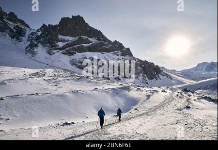 Zwei Wanderer sind Klettern auf der Strecke in der Nähe der Gletscher gegen den blauen Himmel Hintergrund. Outdoor Klettern und Bergsteigen Konzept. Stockfoto