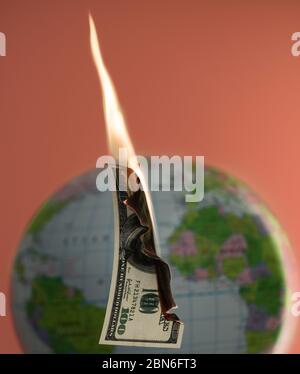 Hundert Dollar Bargeld und Globus hinter dem Hintergrund brennen. Stockfoto