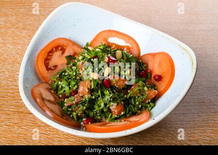 Tabbouleh ist ein levantiner vegetarischer Salat, der hauptsächlich aus fein gehackter Petersilie, mit Tomaten, Minze, Zwiebeln, Bulgur und gewürzt mit Olivenöl, lemo, hergestellt wird Stockfoto