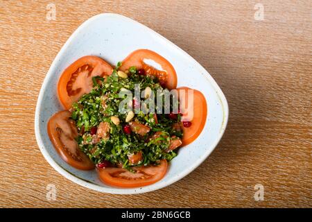 Tabbouleh ist ein levantiner vegetarischer Salat, der hauptsächlich aus fein gehackter Petersilie, mit Tomaten, Minze, Zwiebeln, Bulgur und gewürzt mit Olivenöl, lemo, hergestellt wird Stockfoto