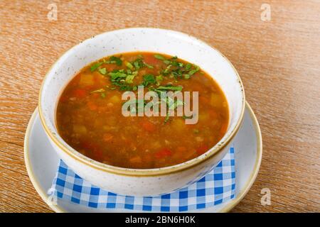 Frische Linsensuppe in einer weißen Schüssel, serviert in einem Restaurant-Setting, selektiver Fokus. Fresh Food Catering Speisen Essen Party Sharing Konzept, Food Deli Stockfoto