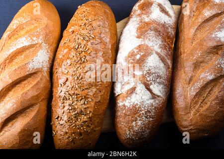 Viele verschiedene Brote und Brötchen von oben geschossen. Draufsicht der Auswahl an verschiedenen Arten von Müsli Bäckerei: Brot, Gebäck, Brötchen, Brezel und Croissant auf Stockfoto