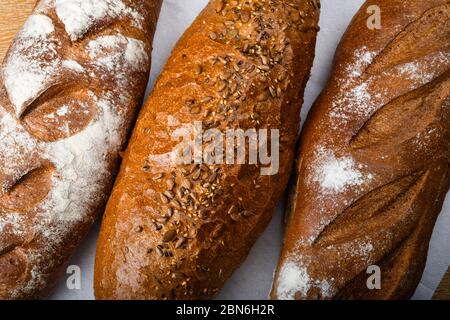 Viele verschiedene Brote und Brötchen von oben geschossen. Draufsicht der Auswahl an verschiedenen Arten von Müsli Bäckerei: Brot, Gebäck, Brötchen, Brezel und Croissant auf Stockfoto