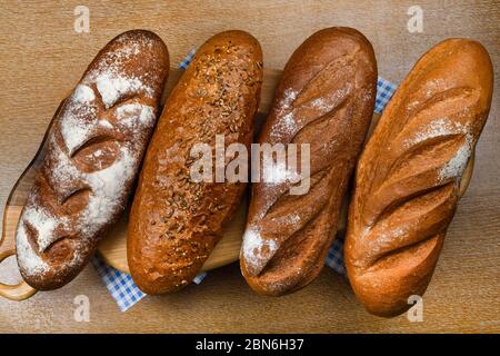 Viele verschiedene Brote und Brötchen von oben geschossen. Draufsicht der Auswahl an verschiedenen Arten von Müsli Bäckerei: Brot, Gebäck, Brötchen, Brezel und Croissant auf Stockfoto