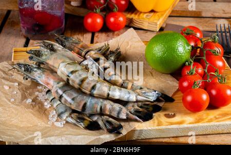Frische rohe Tigergarnelen auf dem Gartentisch. Surf- und Rasenkonzept Stockfoto