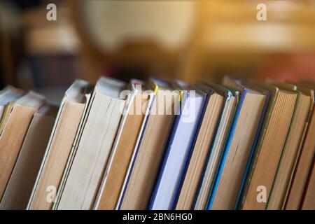 Stapel von Büchern auf einem hölzernen Bücherregal. Stockfoto