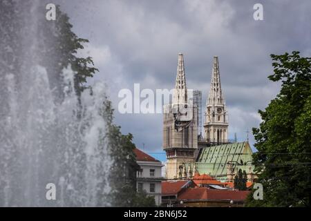 Zagreb, Kroatien - 15 April, 2020 : Zagreb Kathedrale ohne beide Kreuze auf der Spitze der Türme nach dem Erdbeben, die es beschädigt haben und Wasserquelle Stockfoto