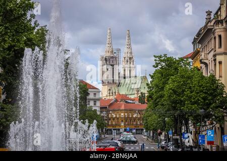 Zagreb, Kroatien - 15 April, 2020 : Zagreb Kathedrale ohne beide Kreuze auf der Spitze der Türme nach dem Erdbeben, die es beschädigt haben und Wasserquelle Stockfoto