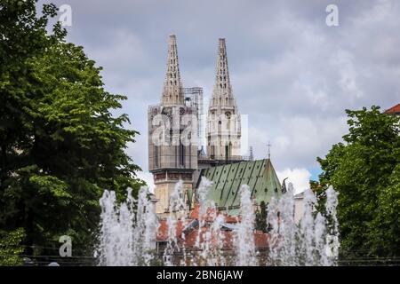 Zagreb, Kroatien - 15 April, 2020 : Zagreb Kathedrale ohne beide Kreuze auf der Spitze der Türme nach dem Erdbeben, die es beschädigt haben und Wasserquelle Stockfoto