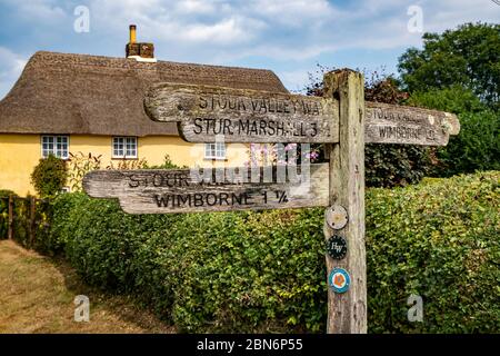 Alte Holzwegweiser mit Wegweiser auf dem Stour Valley Way und dem Hardy Way in Pamphill, in der Nähe von Wimborne, Dorset, England, Großbritannien Stockfoto