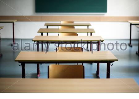 Ein Satz von Schulschreibtischen und Stühlen in einem leeren Klassenzimmer in Deutschland während der Corona-Krise. Stockfoto