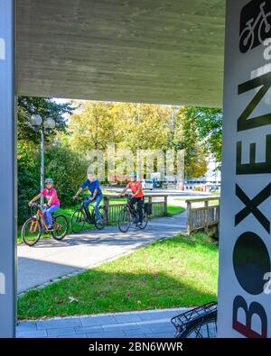 Die gutgelaunte Familie nutzt ein vorbildliches Fahrradparkkonzept für einen Stadtbummel zu Fuß Stockfoto