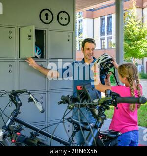 Die gutgelaunte Familie nutzt ein vorbildliches Fahrradparkkonzept für einen Stadtbummel zu Fuß Stockfoto