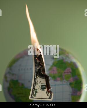 Hundert Dollar Bargeld und Globus hinter dem Hintergrund brennen. Stockfoto