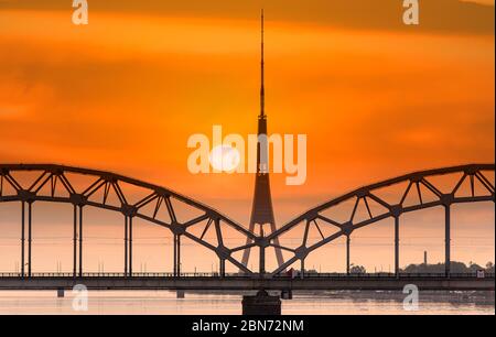 Riga, wundervoller Sonnenuntergang über dem Fluss Daugava, Brücke und Fernsehturm, Lettland Stockfoto