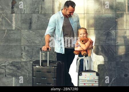 Vater und Tochter stehen zusammen mit ihrem Gepäck am Flughafen. Eine zweiköpfige Familie, die Urlaub gemacht hat. Stockfoto