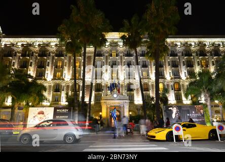 Blick auf das InterContinental Carlton Hotel bei Nacht mit dem gelben Ferrari 458 vor dem Hotel. Croisette in Cannes, Cote d'Azur, Frankreich Stockfoto