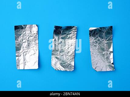 Verschiedene zerknitterte Folie verwendet candy Wrapper auf blauem Hintergrund, Ansicht von oben Stockfoto