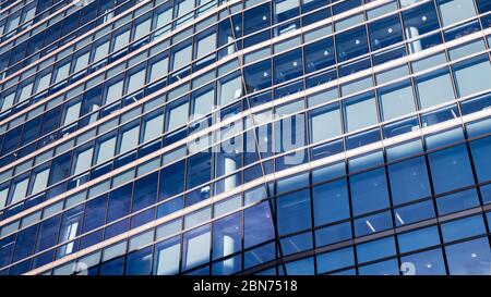 Blaues Geschäftsgebäude. Ein kantiger und abstrakter Vollbildblick auf die Fenster zu einem generischen modernen Bürogebäude. Stockfoto