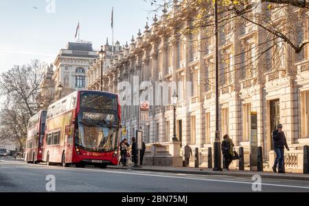 Rote Londoner Doppeldeckerbusse parkten vor dem Kabinettsgebäude in Whitehall, einem von britischen Regierungsgebäuden dominierten Gebiet. Stockfoto