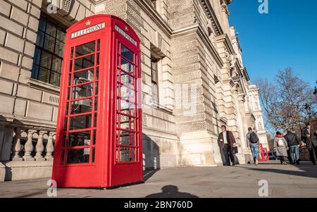 Rote Telefonbox. Ein traditionelles altes rotes UK Telefonfeld vor einem der vielen Regierungsgebäude in Whitehall, London. Stockfoto