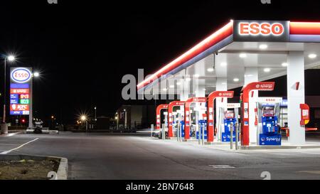 Neue Esso Tankstelle spät in der Nacht gesehen, wie wenige Fahrzeuge füllen sich an den Gaspumpen. Stockfoto