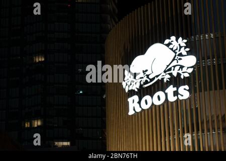 Roots Canada Logo, ein beliebtes kanadisches Unternehmen, das nachts auf einem Geschäft in der Innenstadt von Toronto zu sehen ist. Stockfoto