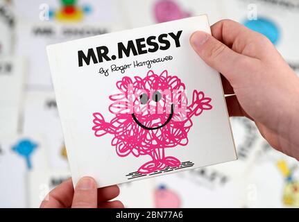 Ein Junge, der das Buch Mr Men lesen möchte, Mr. MESSY von Roger Hargreaves Stockfoto