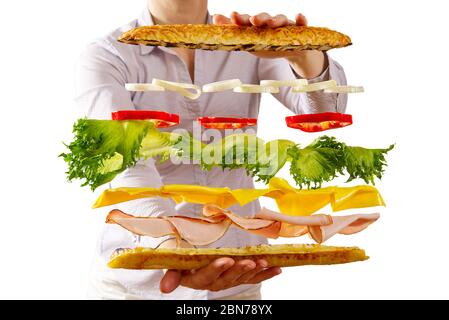 Fliegendes Sandwich. Fliegende Schichten von Sandwich. Gut geröstete Patty, Schinken, Käse und Gemüse zwischen zwei Hälften von ein. Amerikanisches Frühstücksangebot. Stockfoto