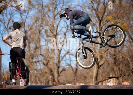 Lemberg, Ukraine - 12. März 2020: Junger Mann, der Tricks auf einem BMX-Fahrrad macht. BMX im Skatepark der Stadt. Teenager fahren mit dem Fahrrad in einem urbanen Bike- und Skatepark Stockfoto