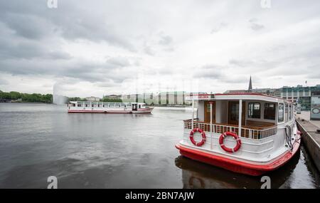 Hamburg, Deutschland. Mai 2020. Ein Lastkahn der Weißen Flotte segelt auf der Binnenalster. Die Schiffe können den Betrieb wieder aufnehmen. Seit Wochen waren die Schiffe aufgrund von Beschränkungen zur Eindämmung der Corona-Pandemie im Stillstand. Quelle: Daniel Reinhardt/dpa/Alamy Live News Stockfoto