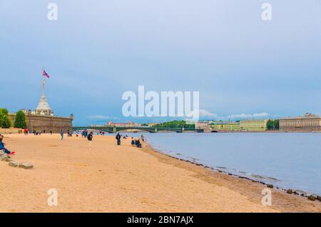 Sankt Petersburg, Russland, 4. August 2019: Sandstrand auf der Insel Zayachy Hare in der Nähe der Peter und Paul Festung und der Dreifaltigkeitsbrücke (Bascule Brücke) über den Neva Fluss im Hintergrund Stockfoto