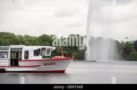 Hamburg, Deutschland. Mai 2020. Ein Lastkahn der Weißen Flotte segelt auf der Binnenalster. Die Schiffe können den Betrieb wieder aufnehmen. Seit Wochen waren die Schiffe aufgrund von Beschränkungen zur Eindämmung der Corona-Pandemie im Stillstand. Quelle: Daniel Reinhardt/dpa/Alamy Live News Stockfoto