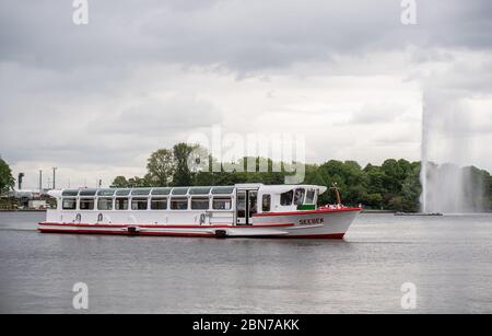 Hamburg, Deutschland. Mai 2020. Ein Lastkahn der Weißen Flotte segelt auf der Binnenalster. Die Schiffe können den Betrieb wieder aufnehmen. Seit Wochen waren die Schiffe aufgrund von Beschränkungen zur Eindämmung der Corona-Pandemie im Stillstand. Quelle: Daniel Reinhardt/dpa/Alamy Live News Stockfoto