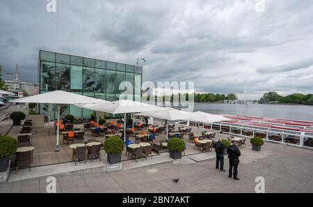 Hamburg, Deutschland. Mai 2020. Die Plätze des Café Mio auf der Binnenalster sind fast schon eine Referenz. Im Hintergrund ein Lastkahn der Weißen Flotte. Seit Wochen lagen die Schiffe wegen der Beschränkungen zur Eindämmung der Pandemie in Corona im Leerlauf. Quelle: Daniel Reinhardt/dpa/Alamy Live News Stockfoto