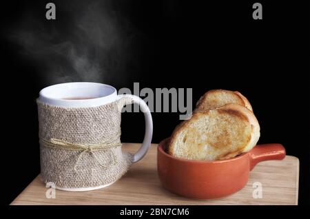 Dampfen von traditionellem schwarzen Kaffee in einem Becher und Toast mit Weißbrot Stockfoto