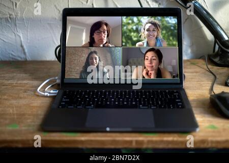 Personen, die online einen virtuellen Anruf tätigen. Laptop auf dem Schreibtisch zu Hause. Freunde und Familie sprechen während der COVID-19 Coronavirus-Pandemie. Stockfoto