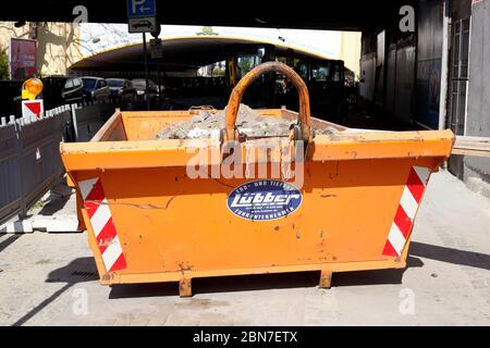 Orange skip für Bauschutt auf einer Baustelle; Deutschland; Europa Stockfoto