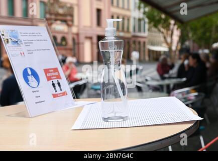 Mainz, Deutschland. Mai 2020. Eine Flasche Handdesinfektionsmittel und eine Tafel stehen den Gästen am Eingang des 'Dom-Cafe' zur Verfügung. Seit dem 13. Mai 2020 dürfen Restaurants und Kneipen in Rheinland-Pfalz unter strengen Auflagen wieder eröffnet werden. Kredit: Arne Dedert/dpa/Alamy Live News Stockfoto